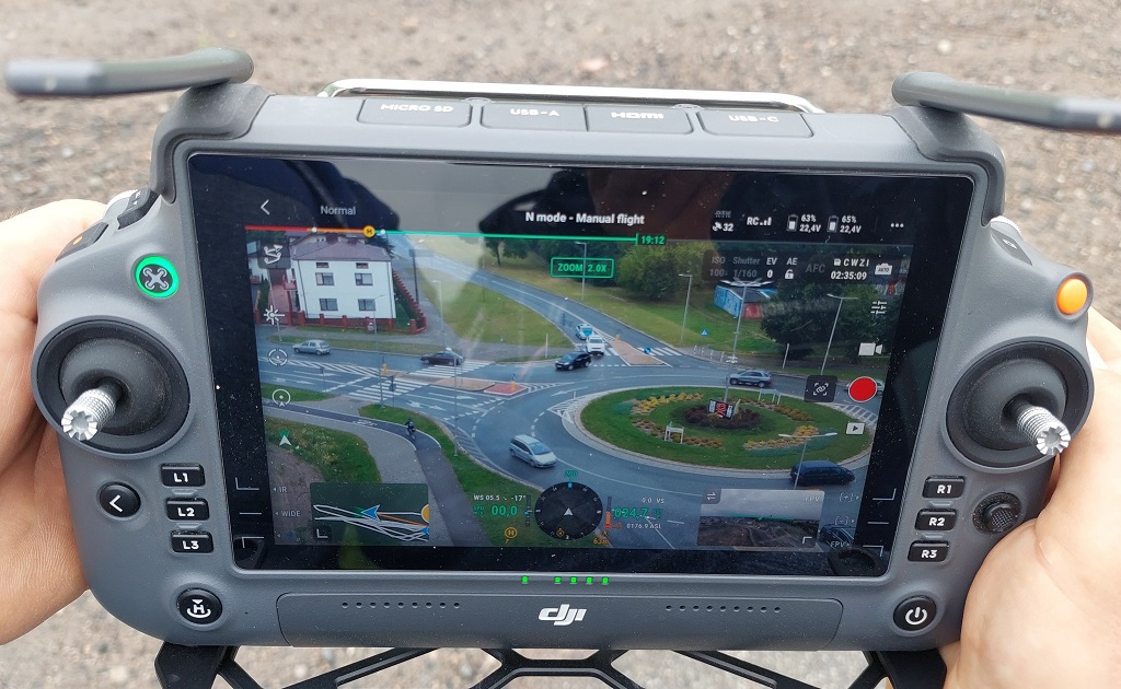 Ekran policyjnego drona z widokiem na rondo i ruch pojazdów