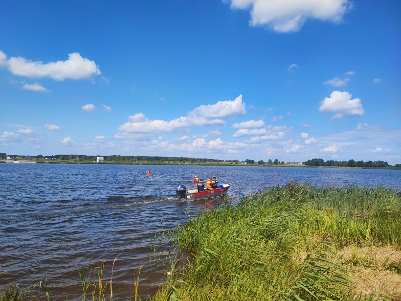 funkcjonariusze w motorówce i pontonie na zbiorniku wodnym