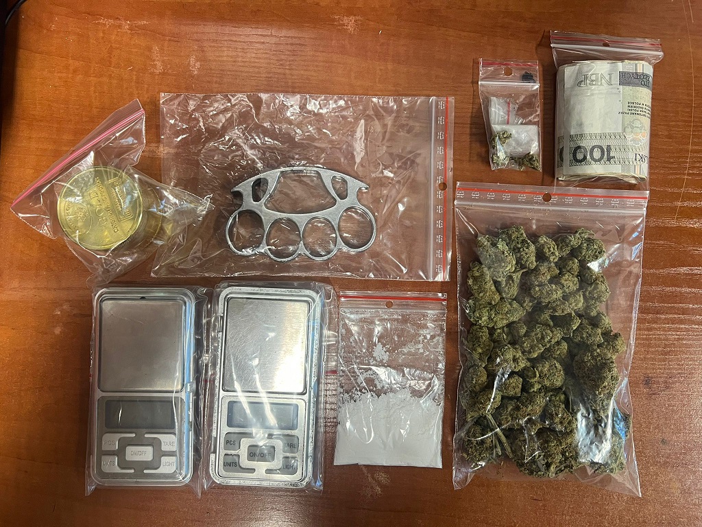 zabezpieczone narkotyki, wagi oraz kastet leżące na stole