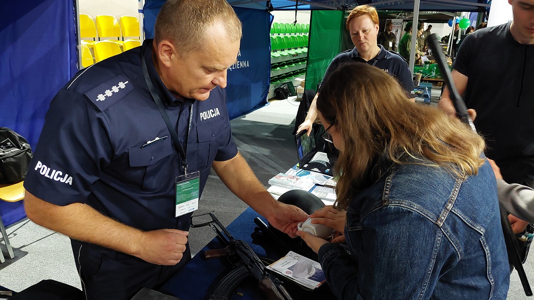 technik pokazuje kandydatowi sposób zabezpiecznaia odbitek linii papilarnych