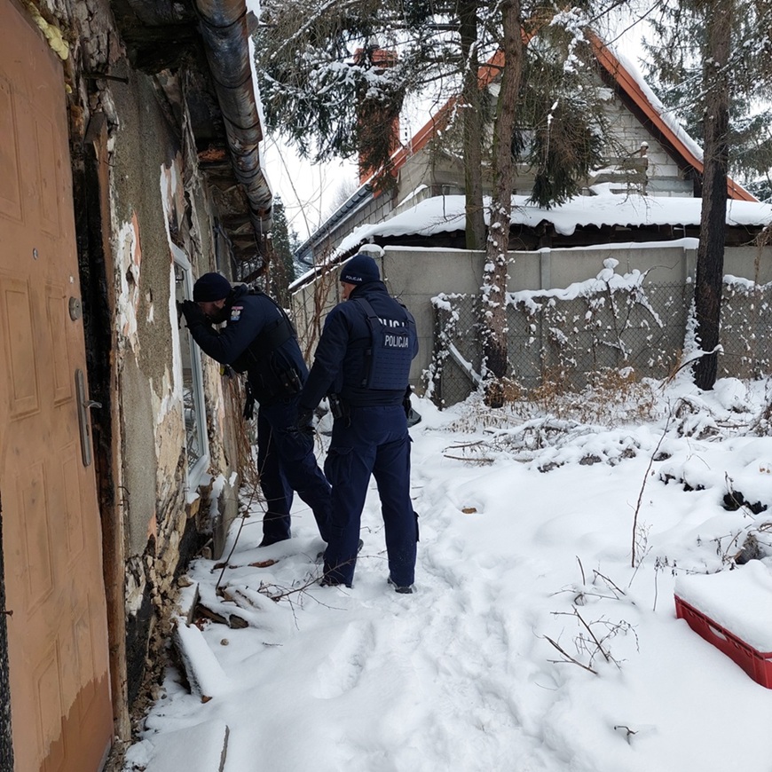 policjant zagląda przez okno zamkniętego pustostanu