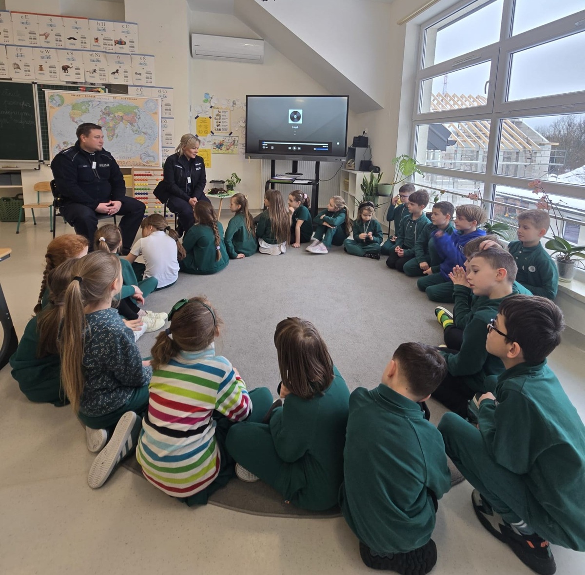 policjanci i dzieci siedzą w kółku