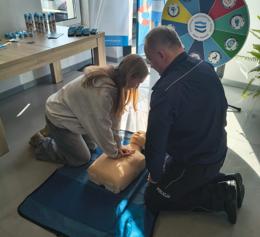 policjant i osobaa ćwicząca na fantomie masaż serca