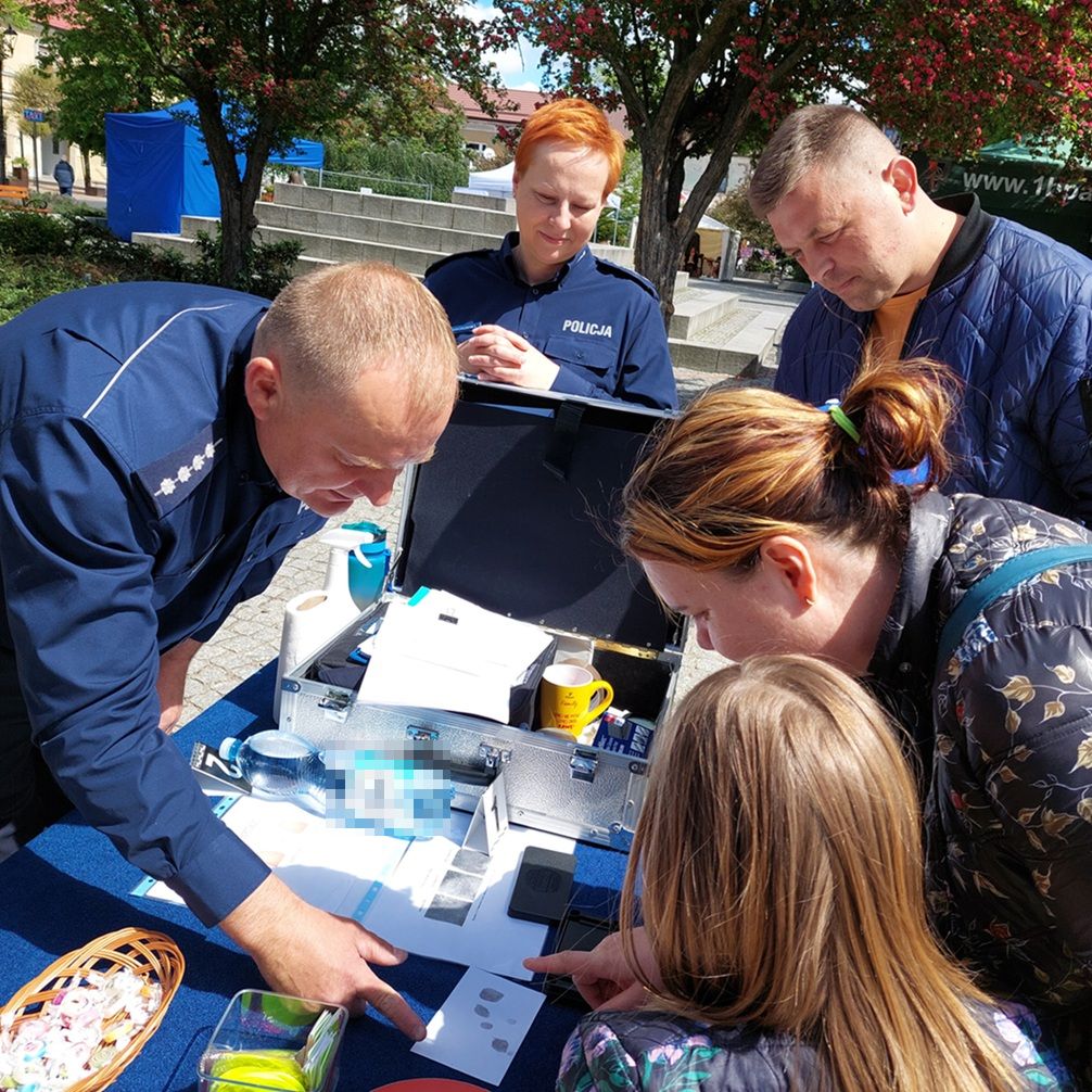 policjanci rozmawiają z dziećmi przy stoisku