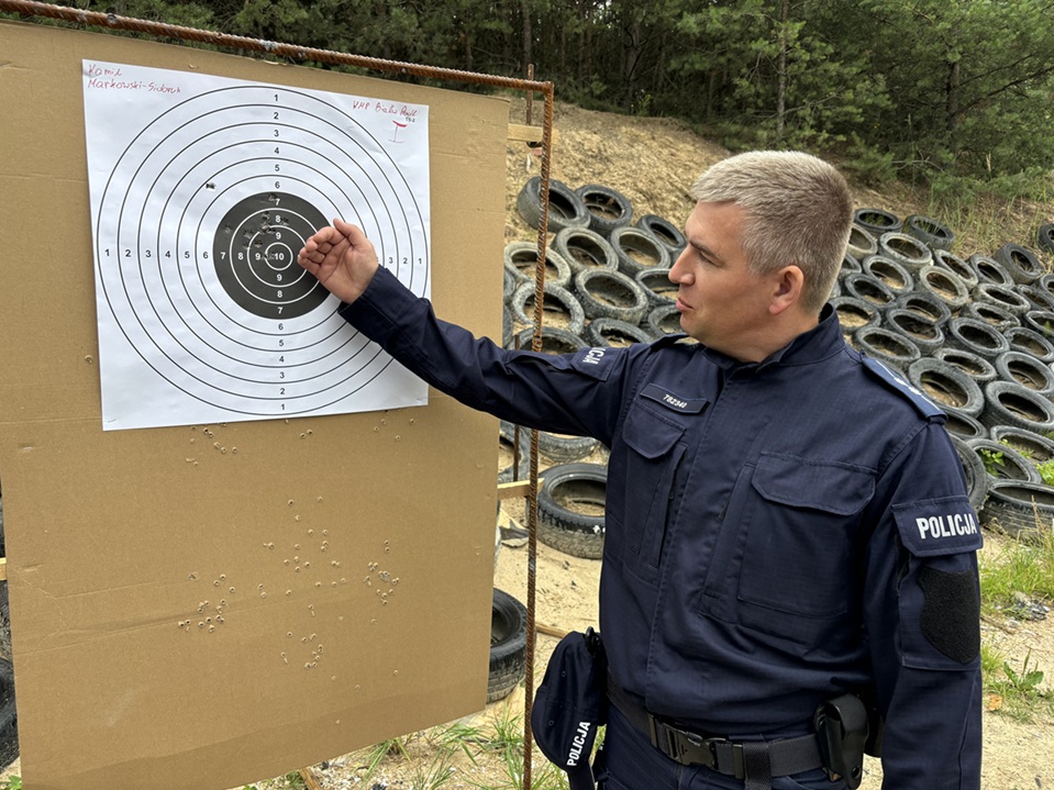 policjant stoi przy tarczy podczas po strzelaniu