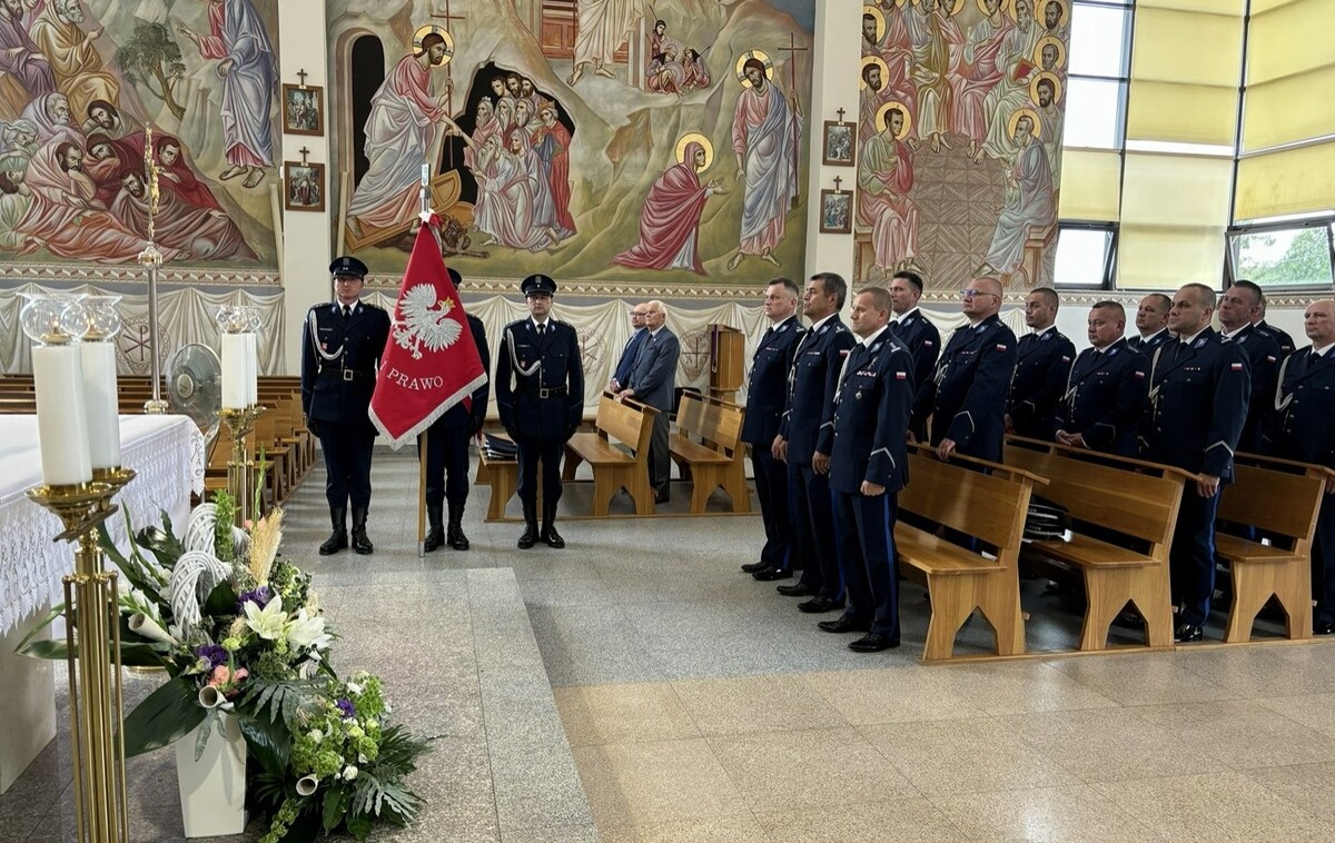policjanci stoją w kościele podczas mszy. Widać poczet sztandarowy