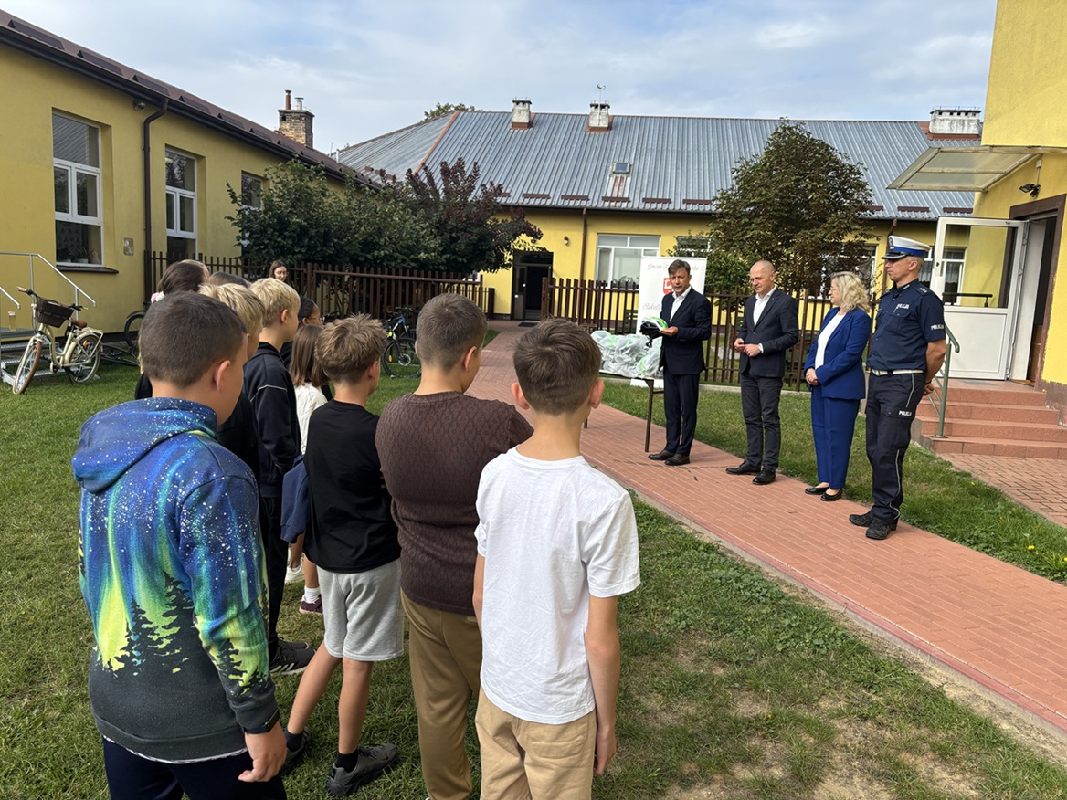 policjant oraz przedstawiciele urzędów podczas spotkania z dziećmi