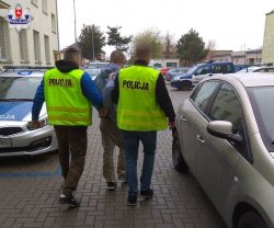 Policjanci idą z zatrzymanym mężczyzną