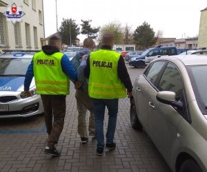 Policjanci idą z zatrzymanym mężczyzną