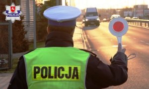 policjant stojący z tarczą do zatrymywania pojazdów