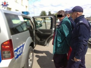 policjanci doprowadzają podejrzanego o zastrzelenie psa