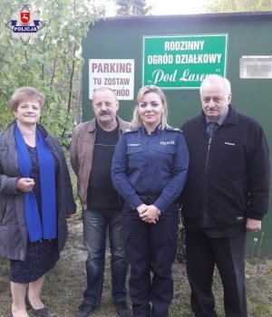 policjantka stojąca z działkowcami