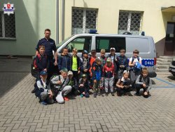 zdjęcie grupowe dzieci zwiedzających komendę przy radiowozie