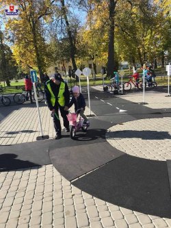policjant tłumaczy dzieciom zasady poruszania się po rondzie