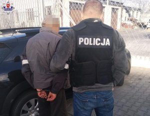 zatrzymany mężczyzna doprowadzany przez policjanta
