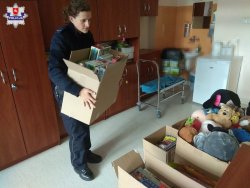 policjantka przynosi pudełka z prezentami dla małych pacjentów