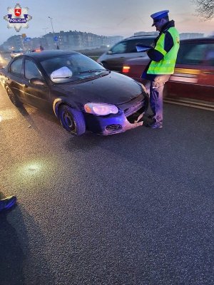 policjant wykonujący czynności służbowe w związku z kolizją, uszkodzony samochód