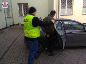 zatrzymany mężczyzna doprowadzony przez policjanta