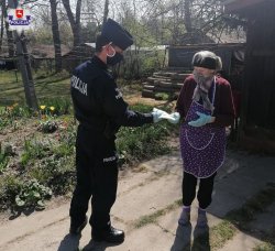 policjant przekazuje maseczkę mieszkance