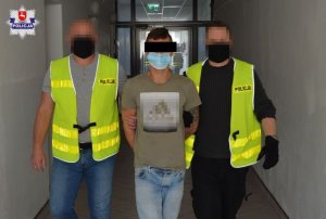 policjanci doprowadzają zatrzymanego