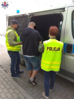 policjanci wprowadzają zatrzymanego do radiowozu