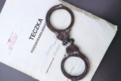 akta postępowania oraz leżące na nich kajdanki