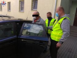 zatrzymany 45-latek doprowadzony przez nieumundurowanych policjantów