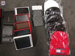 zabezpieczona odzież z podrobionymi znakami towarowymi ułożona w czterech rzędach