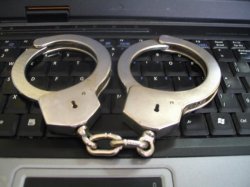 kajdanki leżące na klawiaturze komputera