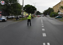 miejsce wypadku drogowego, policjant stoi na drodze