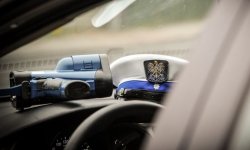 miernik prędkości i czapka policyjna leżące we wnętrzu radiowozu