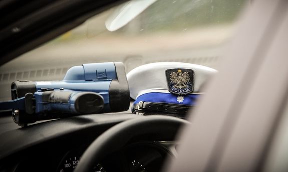 miernik prędkości i czapka policyjna leżące we wnętrzu radiowozu