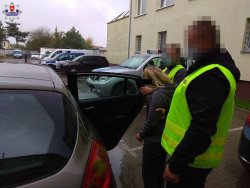 zatrzymana kobieta doprowadzana przez dwóch policjantów