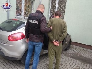 zatrzymany mężczyzna doprowadzany przez policjanta