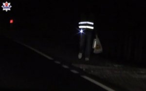 fragment postaci ubranej w kamizelkę odblaskową