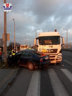 miejsce wypadku policjant stoi przy uszkodzonych pojazdach