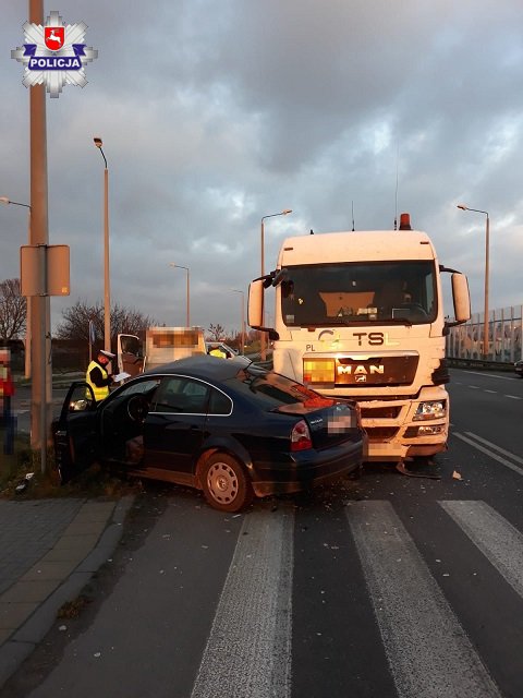 miejsce wypadku policjant stoi przy uszkodzonych pojazdach