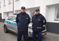 policjanci stoją przy radiowozie