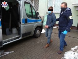 mężczyzna doprowadzany przez funkcjonariusza