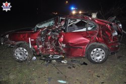 uszkodzony samochód oraz policjanci wykonujący czynności