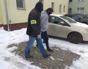 zatrzymany 27-latek doprowadzany przez policjantów