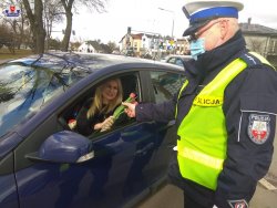policjant wręcza kwiaty kierującej