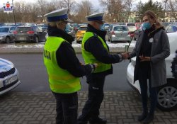 policjant przekazuje kwiaty podczas kontroli drogowej