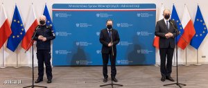 na zdjęciu widać przemawiającego ministra Mariusza Kamińskiego oraz Komendanta Głównego Policji generalnego inspektora Jarosława Szymczyka i Krzysztofa Saczka Głównego Inspektora Sanitarnego