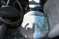 wnętrze uszkodzonego auta, odłamki rozbitego okna leżące na siedzeniu