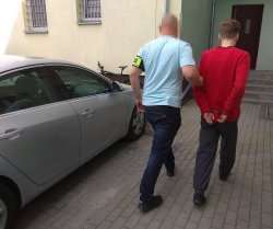 policjant doprowadza zatrzymanego 34-latka