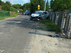 samochód stoi na poboczu drogi obok uszkodzonego ogrodzenia