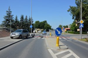 miejsce wypadku drogowego. Toyota stoi częściowo na chodnika, leżący na przejeździe rower, w tle widoczny radiowóz