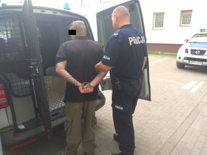 umundurowany policjant wprowadza zatrzymanego 39-latka do radiowozu