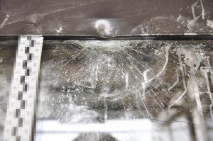 fragment uszkodzonych drzwi, widoczna pęknięta szyba